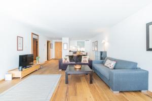 uma sala de estar com um sofá azul e uma mesa em Haus Whymper em Zermatt