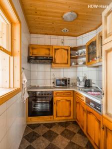 ヴェルニゲローデにあるFerienwohnung An der Malzmühleのキッチン(木製キャビネット、コンロ付)