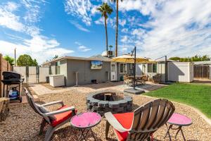 um quintal com uma fogueira e cadeiras e um grelhador em MODERN LIVING! CAMELBACK EAST-BILTMORE HOME em Phoenix