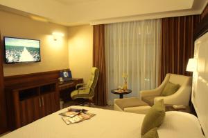 a hotel room with a bed and chairs and a television at Central Park Tower Resort in Angeles