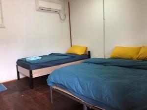 two twin beds in a room with at Tiongman Scubadive & Lodge in Tioman Island