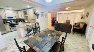 Il comprend une cuisine et un salon avec une table et des chaises. dans l'établissement Las Palmas Resort at Sandy Beach- Condo Grande-605 condo, à Puerto Peñasco