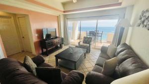 - un salon avec un canapé et une vue sur l'océan dans l'établissement Las Palmas Resort at Sandy Beach- Condo Grande-605 condo, à Puerto Peñasco