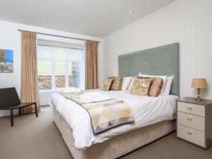 a bedroom with a large bed and a window at 15 Dart Marina in Dartmouth