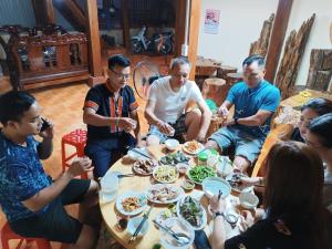 a group of people sitting around a table eating food at Homestay duy mạnh gần suối nước khoáng nóng trạm tấu in Cham Ta Lao