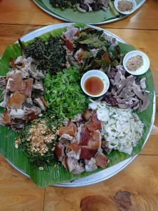 een groene plaat met eten op een tafel bij Homestay duy mạnh gần suối nước khoáng nóng trạm tấu in Cham Ta Lao