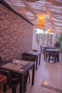 a restaurant with tables and chairs and a brick wall at Aguacatala Hotel Boutique in Medellín