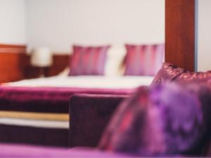 sypialnia z łóżkiem z fioletową pościelą i poduszkami w obiekcie Hotel Chmielna Warsaw w Warszawie
