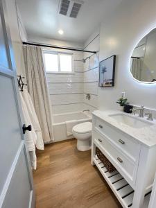 a white bathroom with a toilet and a sink at El Nido Beachlife Cottage in South Bay Los Angeles in Redondo Beach