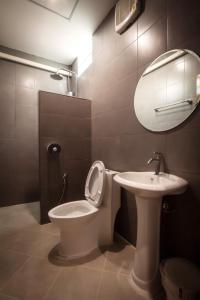 帕堯的住宿－โรงแรมบ้านมะกรูด Baan Ma Grood Hotel，一间带卫生间、水槽和镜子的浴室