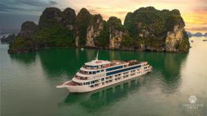 un navire de croisière dans l'eau devant des falaises de calcaire dans l'établissement Hi-Home Suites - Ngoai Giao Doan at West Lake Starlake, à Hanoï