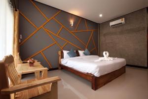 Postel nebo postele na pokoji v ubytování โรงแรมบ้านมะกรูด Baan Ma Grood Hotel