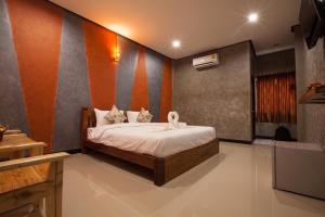 a bedroom with a bed in a room at โรงแรมบ้านมะกรูด Baan Ma Grood Hotel in Phayao