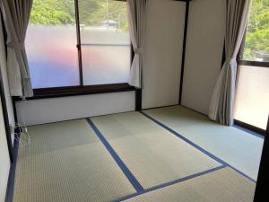 Habitación con 2 ventanas y suelo de rayas azules. en リベラ小波月古民家再生 海岸横プライベートビーチ並み, en Iwada 35 fotos más