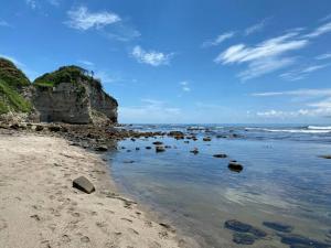 a beach with some rocks in the water at リベラ小波月古民家再生 海岸横プライベートビーチ並み in Iwada