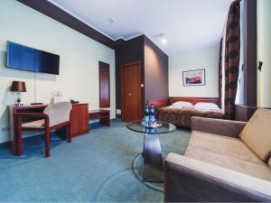 pokój hotelowy z łóżkiem, kanapą i stołem w obiekcie Hotel Chmielna Warsaw w Warszawie