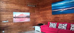 فيلا إيكو سيمينياك في سمينياك: أريكة حمراء في غرفة مع جدران خشبية