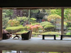 a view of a garden through a large window at Hanabishi Hotel in Hakodate