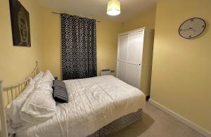 1 dormitorio con 1 cama y reloj en la pared en Two Bedroom Entire Flat in Darlington with Free Parking, WiFi and lots more, en Darlington