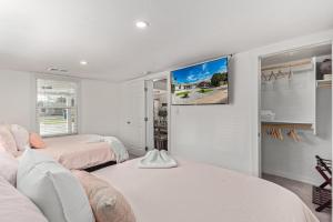 a bedroom with two beds and a tv on the wall at MODERN LIVING! CAMELBACK EAST-BILTMORE HOME in Phoenix