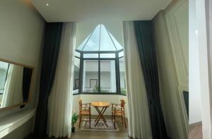 una sala da pranzo con tavolo e finestra di Grand Lord Hotel & Residence a Na Jomtien