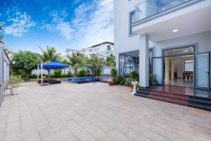 eine große Terrasse in einem weißen Haus in der Unterkunft Luxury Chilinh - Large Swimming Pool - 200M To The Sea in Vũng Tàu