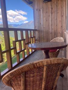una mesa y sillas en un balcón con vistas en Phamlhakhang Ecohomestay, en Pelling