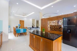 eine Küche mit einem schwarzen Kühlschrank und einem Esszimmer in der Unterkunft Luxury Chilinh - Large Swimming Pool - 200M To The Sea in Vũng Tàu