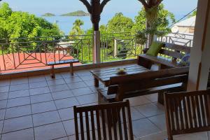 a balcony with benches and a view of the ocean at GRANDE Villa THEANA in Bouillante