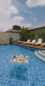 a table with plates of food in a swimming pool at Casa Batu Belig in Seminyak
