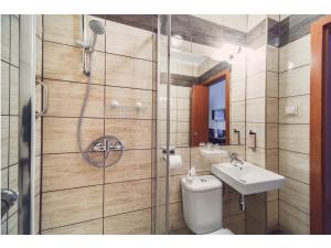 a bathroom with a shower and a toilet and a sink at Hotel Chmielna Warsaw in Warsaw