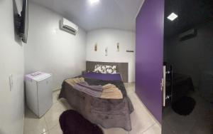 1 dormitorio con 1 cama con paredes moradas en Hotel Boutique Boa Vista, en Boa Vista
