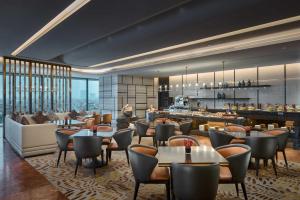 上海市にあるPrimus Hotel Shanghai Hongqiaoのテーブルと椅子のあるレストラン、バー