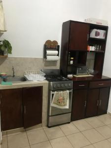 a kitchen with a stove and a sink and a microwave at Hogar dulce hogar! in San Miguel