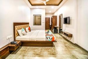 a bedroom with a bed and a flat screen tv at FabHotel Global Inn I Aurangabad Railway Station in Aurangabad