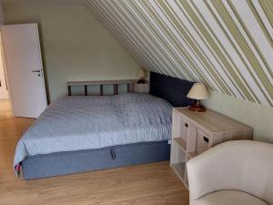 a small bedroom with a bed and a chair at Ferienwohnung mit Seeblick am Groß Labenzer See in Klein Labenz