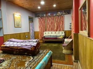 a bedroom with a bed and a couch in a room at Vamoose Mendo Lamu Homestay in Darjeeling