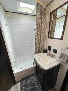 a bathroom with a sink and a shower and a tub at Rv for up to 6 people in Naples
