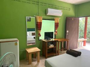 a bedroom with green walls and a desk with a computer at ABC Bungalow in Ban Tai