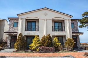 a house with columns and trees in front of it at ArdenHill Resort & Golf in Jeju