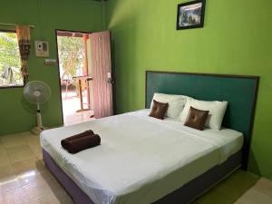 1 dormitorio con 1 cama grande y paredes verdes en ABC Bungalow, en Baan Tai