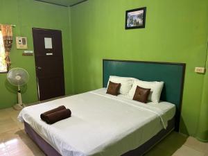 1 dormitorio con 1 cama grande y paredes verdes en ABC Bungalow, en Baan Tai