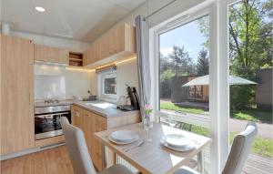 a kitchen with a dining table and a large window at Tiny Haus 24 Am Brombachsee in Pleinfeld