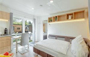 małą sypialnię z łóżkiem i kuchnią w obiekcie Tiny Haus 24 Am Brombachsee w mieście Pleinfeld