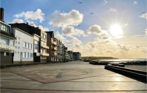 ヴィムルーにあるGorgeous Apartment In Wimereux With House Sea Viewの空を飛ぶ鳥や建物のある通り