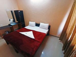 KumtaSTAYMAKER Varad International的一间卧室配有一张带红色毯子的床