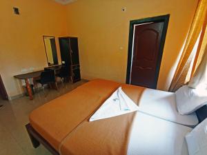 KumtaSTAYMAKER Varad International的酒店客房,配有一张带浴袍的床