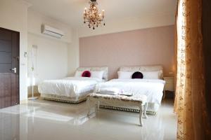 a bedroom with two beds and a chandelier at Dear B&B in Hualien City