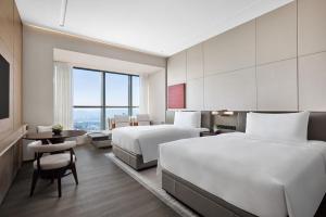 una camera d'albergo con due letti e un tavolo di JW Marriott Hotel Changsha a Changsha