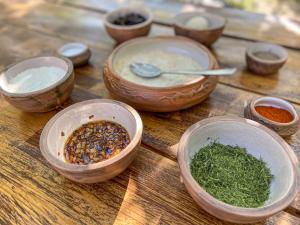 una mesa de madera cubierta con cuencos de madera llenos de hierbas en Noosh guesthouse en Ashnak